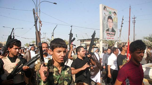 Un grupo de seguidores del EI marchan con sus armas al hombro por las calles de Iraq