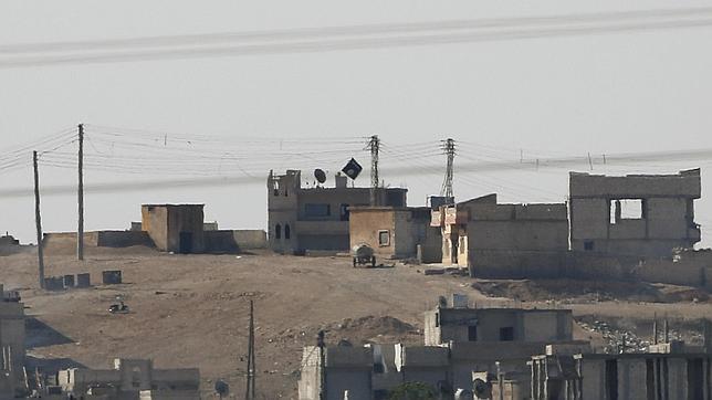 La bandera negra del Estado Islámico ondea en Kobani fotografiada desde la frontera turca