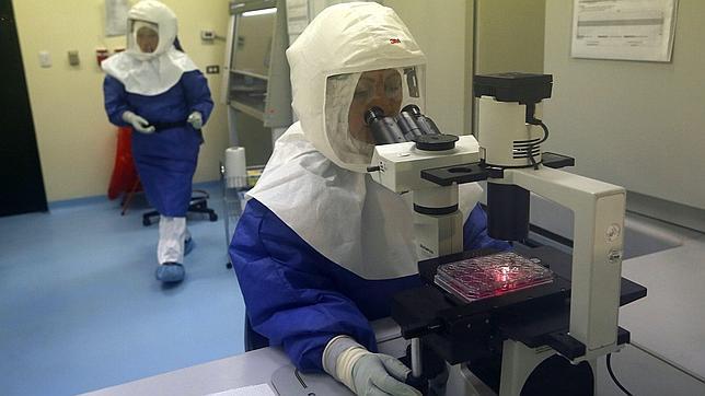 Un médico utiliza un microscopio para observar muestras de virus en un laboratorio de Bioseguridad Nivel III