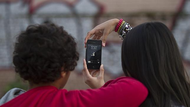 Dos menores juegan con un teléfono