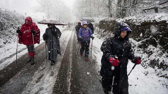 Peregrinos haciendo el camino de Santiago en pleno temporal