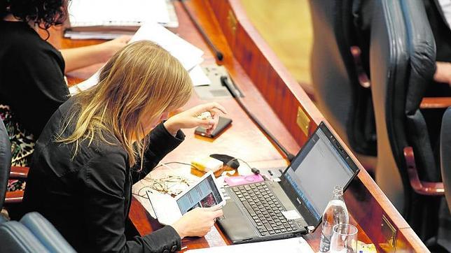 Una diputada consulta su tableta