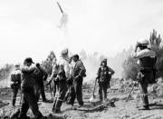 En la imagen, integrantes de las brigadas contra incendios observan al helicóptero de Puerto del Pico, que realiza su función