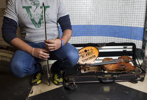Alejandro, que prefiere no mostrar su rostro, junto a su violín