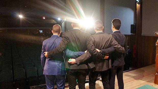 Los jóvenes, espaldas en el salón de actos de su colegio al término del acto de su graduación
