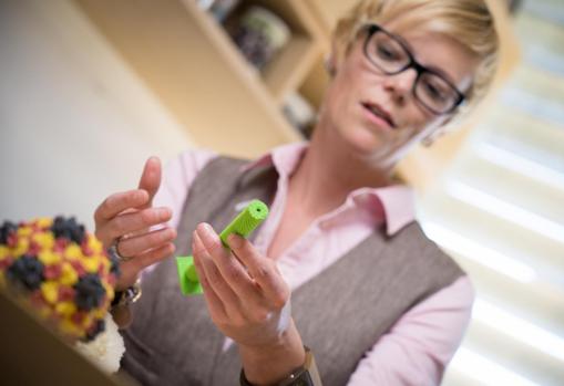 La investigadora Nicole Steinmetz sostiene un modelo del virus del mosaico del tabaco en su despacho