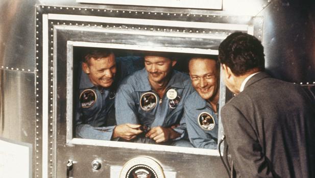 Nixon saluda a los tres astronautas del Apolo 11 en su cuarentena, tras su regreso a la Tierra