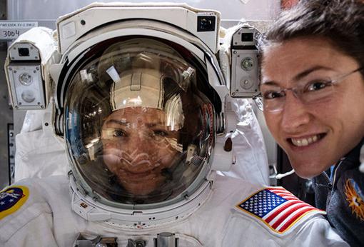 Astronaut Christina Koch (right) poses with her partner Jessica Meir (left), in a space suit