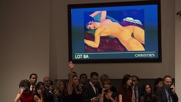 Una trabajadora de Christie's, que representa a un cliente, puja durante la subasta de «Nu Couche», de Amedeo Modigliani
