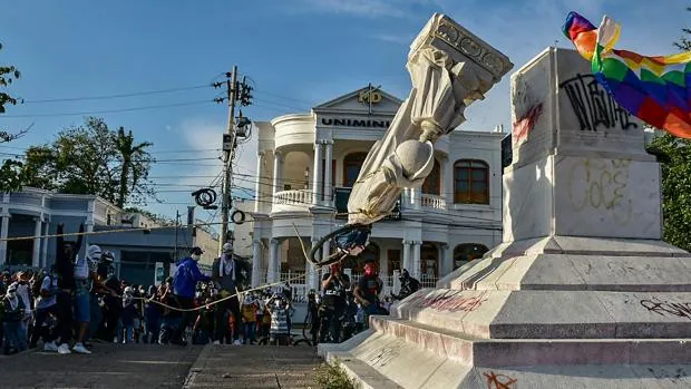 Los manifestantes derriban una estatua de Cristóbal Colón durante una manifestación contra el gobierno en Barranquilla