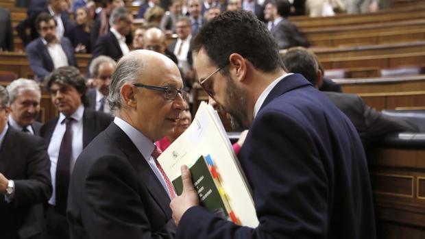El portavoz del grupo socialista, Antonio Hernando (d), y el ministro de Hacienda, Cristóbal Montoro (i), al finalizar un pleno del Congreso de los Diputados