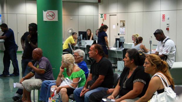 Un grupo de desempleados esperando en una oficina de empleo en Alicante