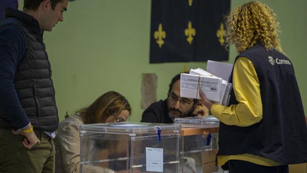 Una trabajadora de Correos deposita los votos realizados por correo