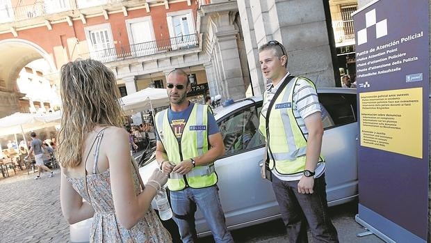 Dos policías municipales atienden a una turista en la Plaza Mayor, en una imagen de archivo