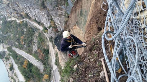 Un operari realitza treballs d'instal·lació en el vessant de Cortes de Pallás