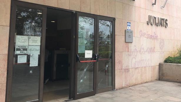 Entrada de los Juzgados de Gavá (Barcelona) con los critales rotos y restos de las pintadas
