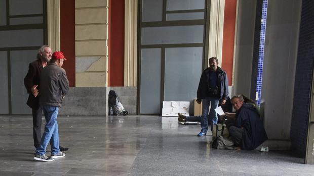 Un grupo de personas sin hogar en el vestíbulo de Príncipe Pio