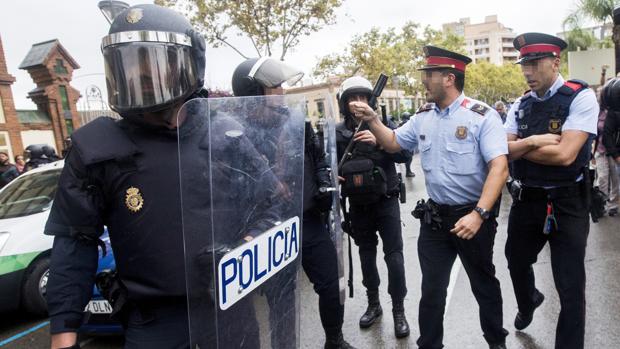 Agentes antidisturbios de la Policía Nacional y de los Mossos d' Esquadra discuten en Barcelona en el 1-O