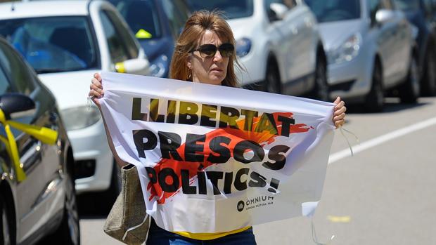 Una mujercon una parcarta a favor de la libertad de los soberanistas presos, en la prisión de Lledoners, en julio