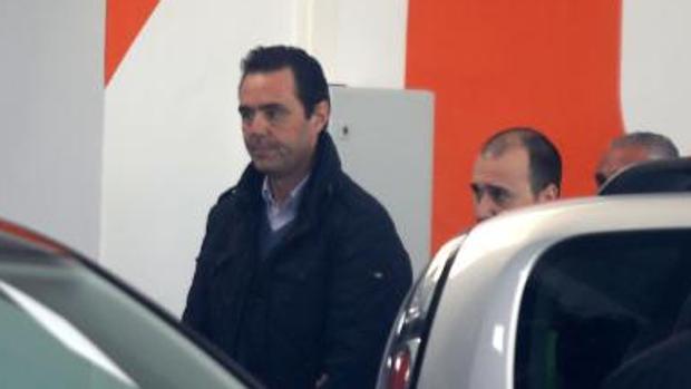 Miguel López custodiado por policías en el lugar del crimen, el concesionario de coches que regentaba