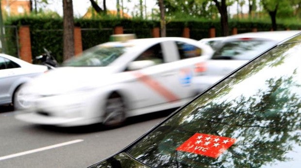 Un VTC frente a una bolsa de taxis en Madrid