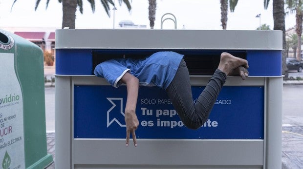 Imagen de archivo de un menor no acompañado entrando en el contenedor en el que duerme, en Melilla