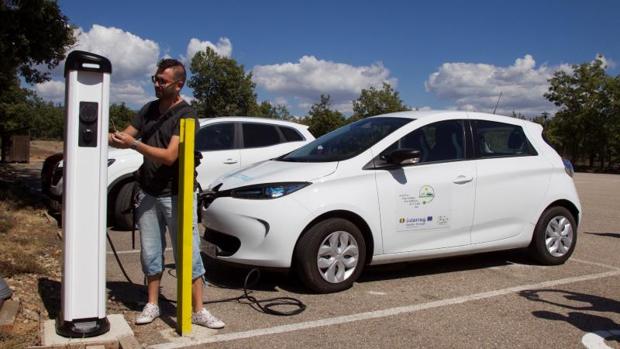 Un conductor recarga un coche eléctrico
