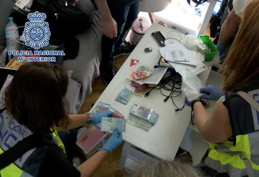Agentes contando el abundante dinero en efectivo localizado en uno de los registros