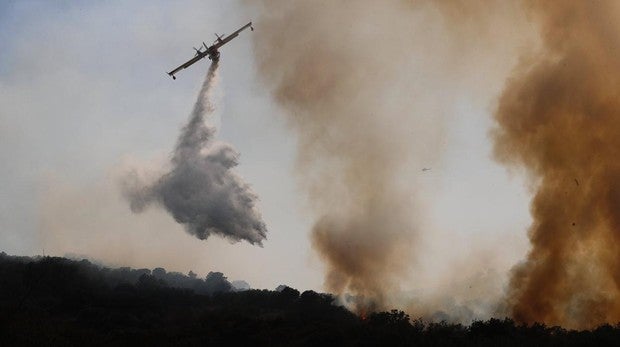 Un hidroavión suelta agua sobre las llamas en el incendio de Cadalso de los Vidrios y Cenicientos