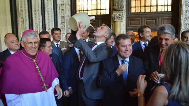 El arzobispo de Toledo sontríe en el claustro de la catredral junto a Page y Tolón mientras Gutiérez bebe del botijo
