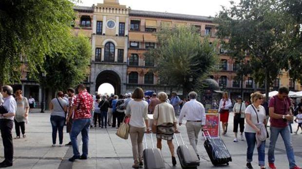 Imagen de turistas con sus maletas por la plaza de Zocodover de Toledo
