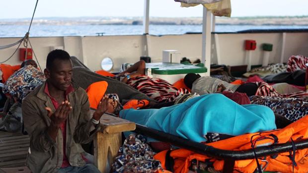 Un migrante reza, este lunes, en el Open Arms, frente a la isla de Lampedusa (Italia)