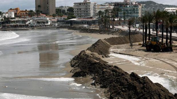 Muro de arena para contención del agua por el temporal en la playa de Jávea (Alicante)