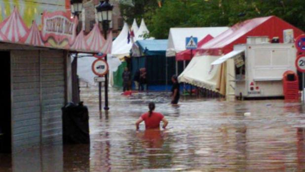 Una mujer camina por la zona inundada donde estaban las atracciones de feria