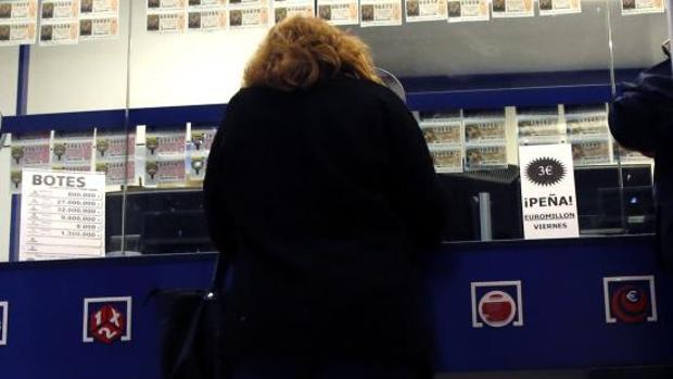 Una mujer compra lotería en una administración alicantina