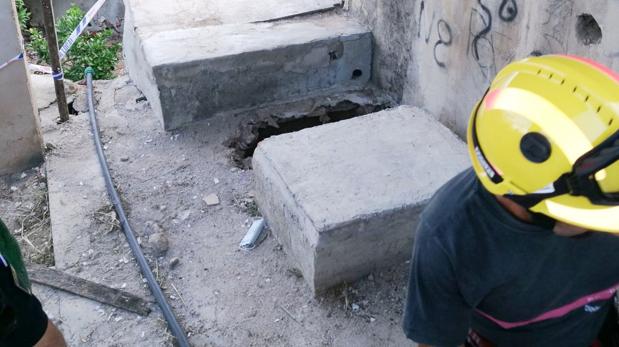 Uno de los bomberos que ha participado en el rescate, junto al pozo con el agujero por el que ha caído la chica accidentalmente