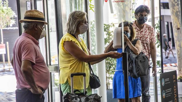 Imagen de dos turistas a las puertas de un hotel de Benidorm