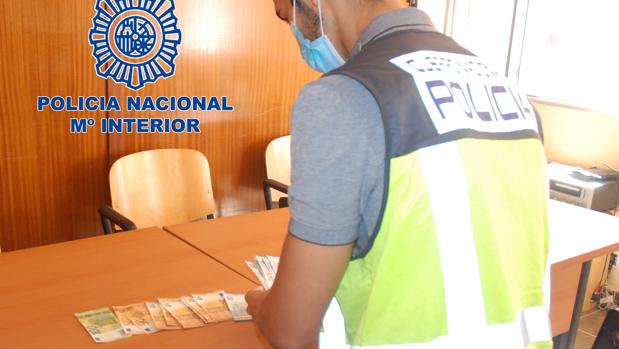 Un policía revisa los billetes falsos intervenidos