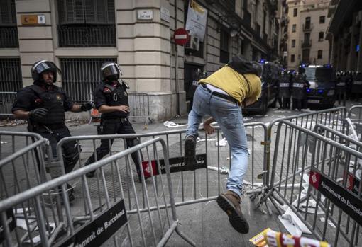 Un independentista vuelve a la manifestación tras hacerse el gallito por unos segundos saltando la valla de protección de la Comisaría de la Policía Nacional / ADRIÁN QUIROGA
