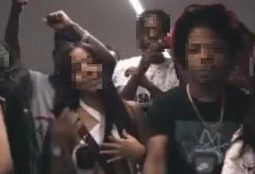 The rapper (right), in a music video with younger girls