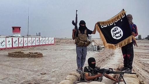 Varios combatientes de Estado Islámico muestran una bandera de la organización terrorista