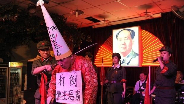 Representación teatral de la humillación y la ejecución de hombre durante la Revolución Cultural en un restaurante de china