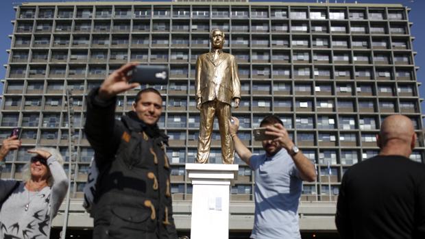 Un grupo de personas se acerca para ver una estatua dorada que representa al primer ministro israelí, Benjamín Netanyahu,