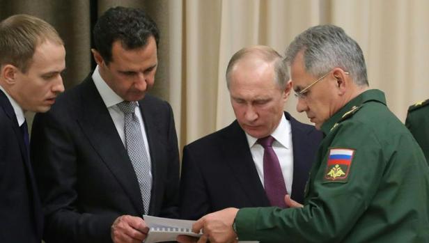 Vladimir Putin (c)y Bashar al Assad, en presencia del ministro de Defensa ruso, Sergei Shoigu, este lunes en Sochi (Rusia)