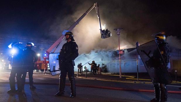Policías anti disturbios vigilan una calle de Nantes mientras actúan los bomberos