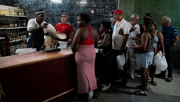 Un grupo de personas hace cola para comprar arroz en un establecimiento estatal
