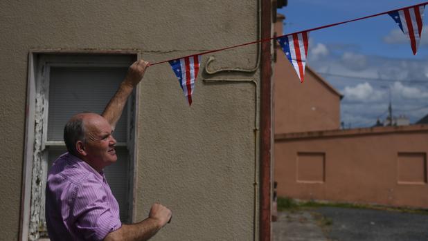 Un hombre coloca banderines con los colores de Estados Unidos en Doonbeg (Irlanda)