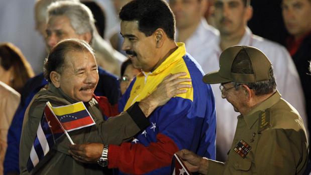 El presidente de Nicaragua, Daniel Ortega abraza a su homólogo venezolano, Nicolás Maduro, mientras el presidente de Cuba, Raúl Castro, observa a los dos líderes