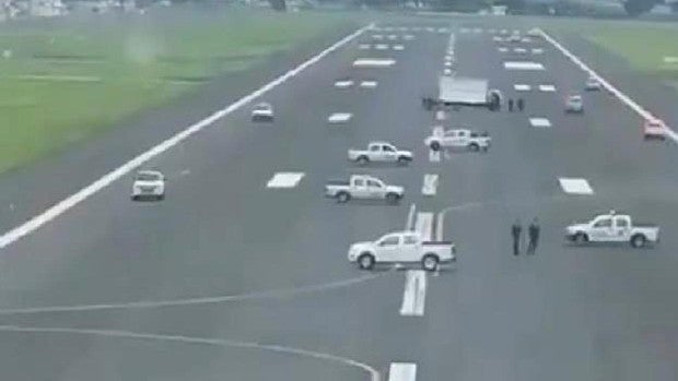 Coches en una pista de un aeropuerto de Ecuador para impedir el aterrizaje de un avión de Iberia