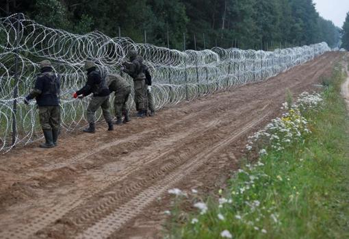 Soldados polacos instalan concertinas en Nomiki, en la frontera con Bielorrusia